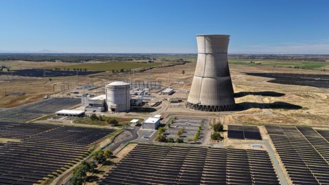 Aerial shot of Rancho Seco Solar Power Plant with large cooling tower and solar panels.