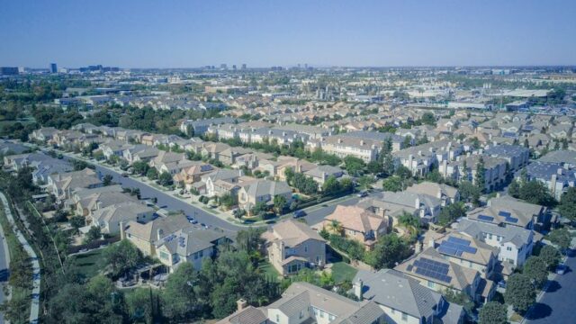 Aerial view of suburban homes in California with solar panels, showcasing sustainable living.