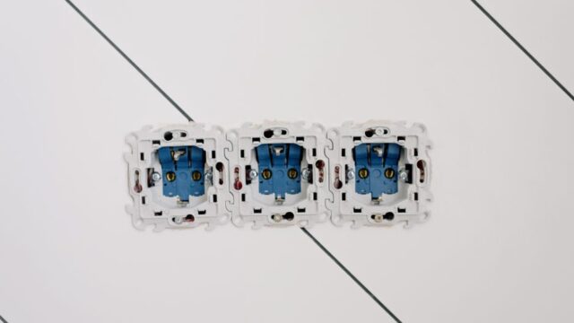 Power sockets with various connectors and bolts on wall in room at home