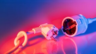 Close-up of electric plug and socket with vibrant lighting, showcasing technology and energy concepts.