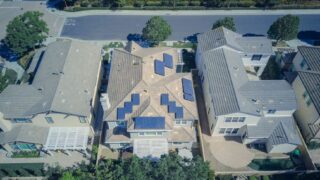 Aerial view of suburban houses equipped with solar panels for renewable energy.