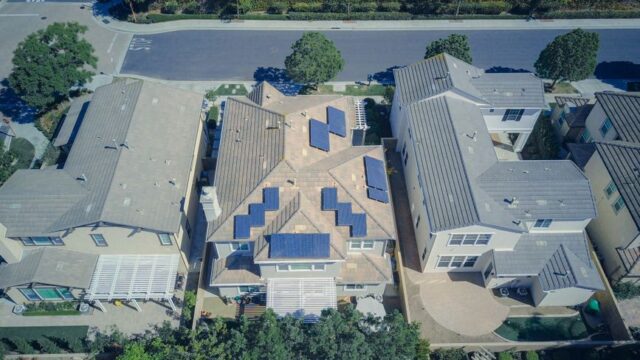 Aerial view of suburban houses equipped with solar panels for renewable energy.