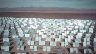 Expansive solar panel field in a sunny desert, capturing renewable energy.