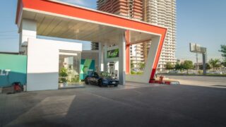 Electric vehicle at a modern charging station in an urban setting, promoting sustainability.
