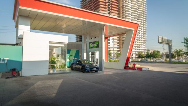 Electric vehicle at a modern charging station in an urban setting, promoting sustainability.