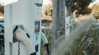 Electric vehicle charging station in an outdoor natural setting, highlighting sustainable technology.