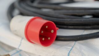 Detailed view of a red industrial electrical cable plug with visible pins.
