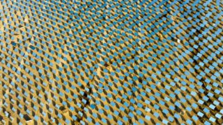 Aerial shot of a solar panel field in a desert, showcasing sustainable energy technology.