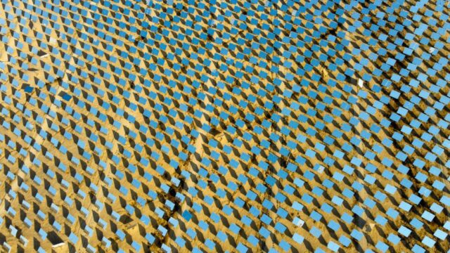 Aerial shot of a solar panel field in a desert, showcasing sustainable energy technology.