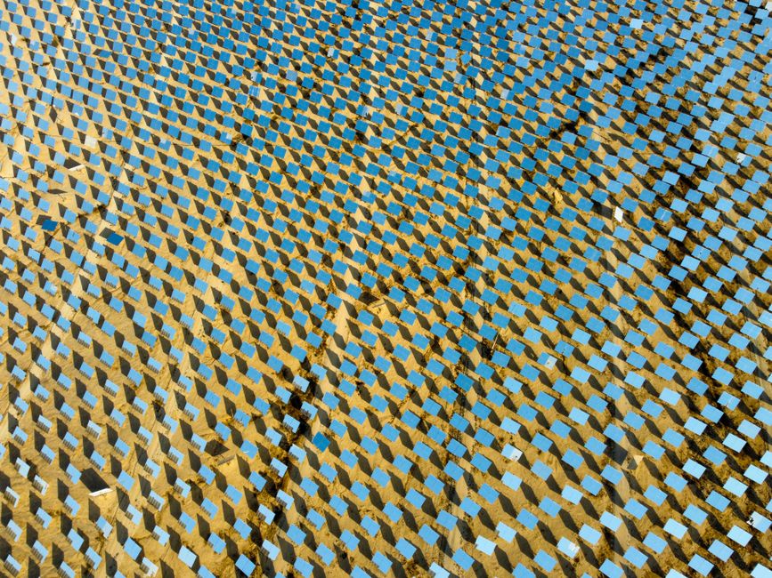 Aerial shot of a solar panel field in a desert, showcasing sustainable energy technology.