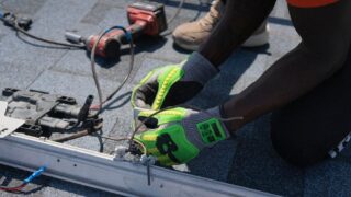 Technician installing solar panels on a roof in Tampa, showcasing clean energy efforts.
