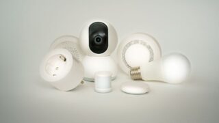 A collection of smart home devices including bulbs, sockets, and cameras on a white backdrop.