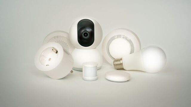 A collection of smart home devices including bulbs, sockets, and cameras on a white backdrop.