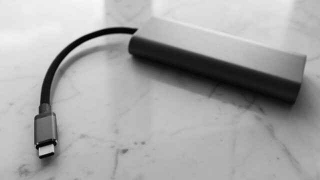 Small plastic external power bank with short wire placed on white marble table