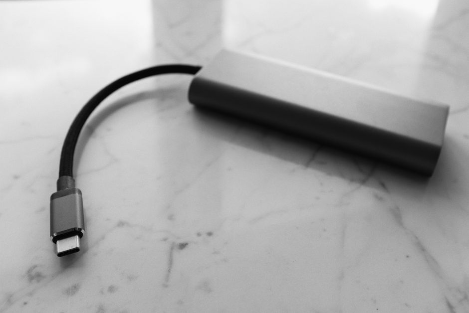 Small plastic external power bank with short wire placed on white marble table