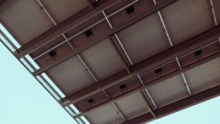 Close-up view of solar panels with a blue sky, showcasing renewable energy architecture.