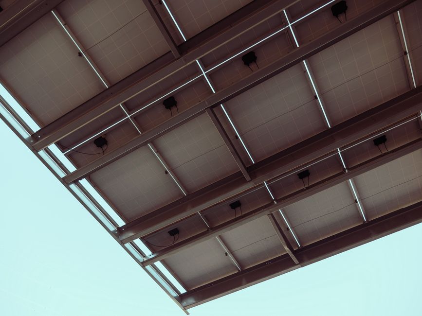 Close-up view of solar panels with a blue sky, showcasing renewable energy architecture.