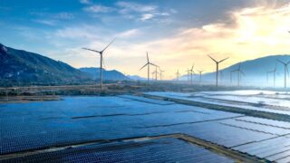 Stunning landscape featuring solar panels and wind turbines at sunrise, symbolizing sustainable energy.