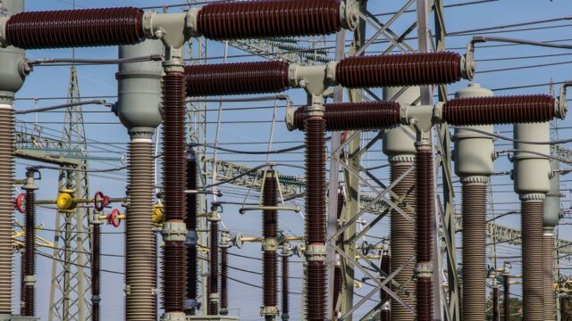 Detailed view of high voltage electrical substation with transformers and power lines.
