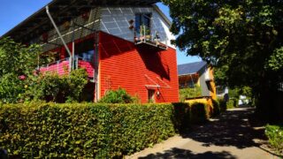 Contemporary solar-powered house in Freiburg surrounded by lush gardens, showcasing eco-friendly architecture.