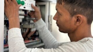 Focused electrician adjusting circuit breaker panel. Technology and skill in action.
