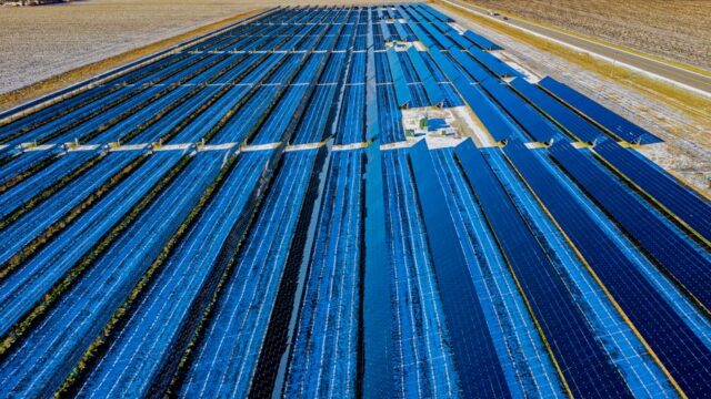 Expansive aerial view of solar panels in Claremont, MN, highlighting renewable energy.