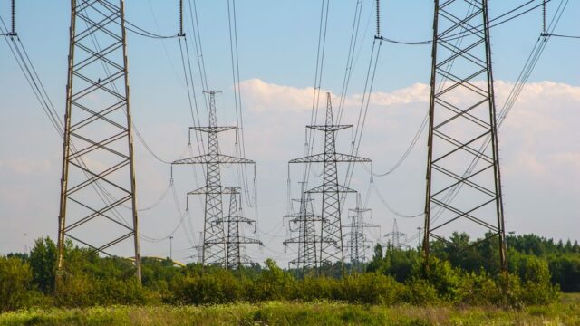 High voltage power lines amidst a countryside setting, showcasing energy infrastructure.