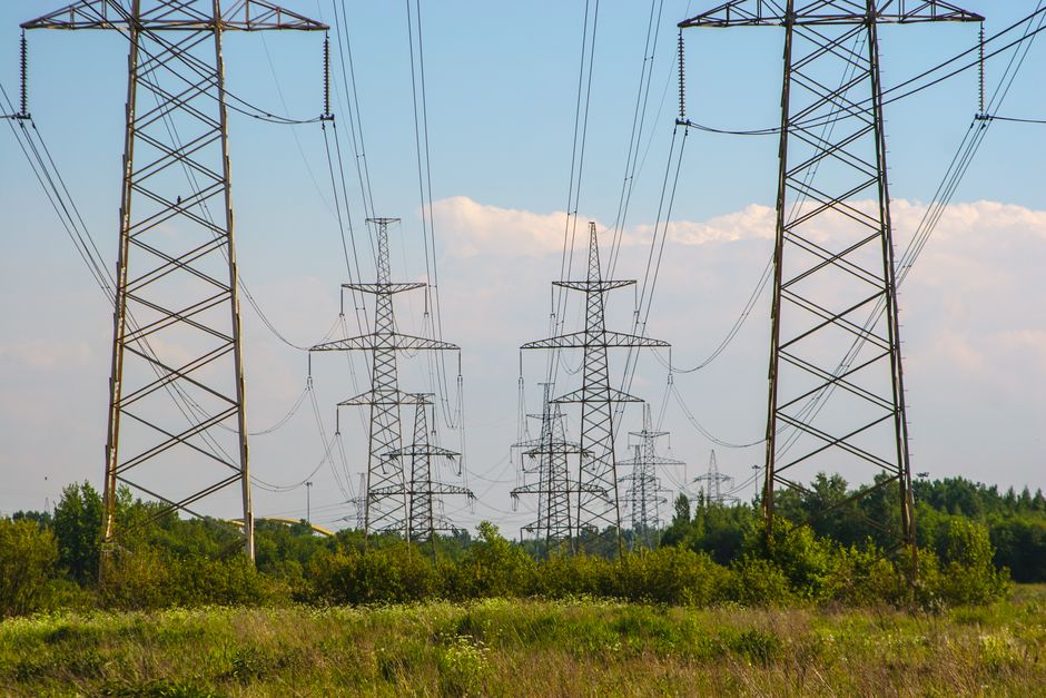 High voltage power lines amidst a countryside setting, showcasing energy infrastructure.