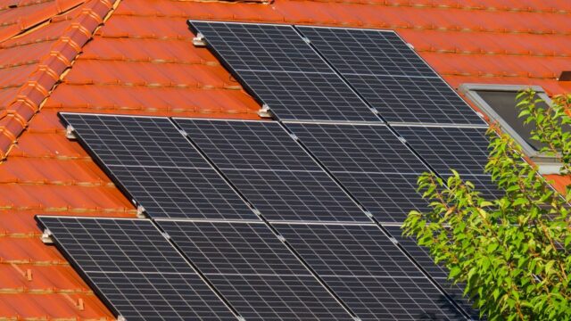 Close-up of solar panels on a red tiled roof in Croatia, highlighting renewable energy.
