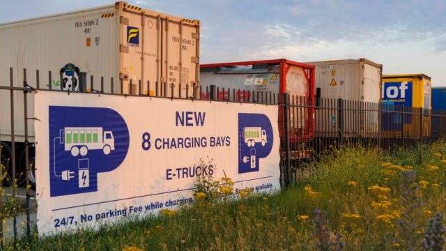 Electric truck charging station at sunset in Rotterdam showcasing sustainable transport.