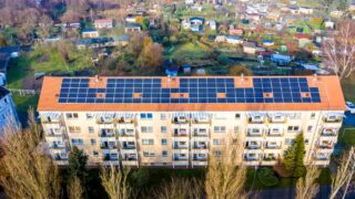 Aerial view of apartment complex with solar panels on rooftop in Beeskow, Germany.