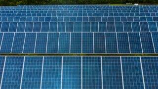 Contemporary installation of solar panels mounted on field in environmental friendly solar power station