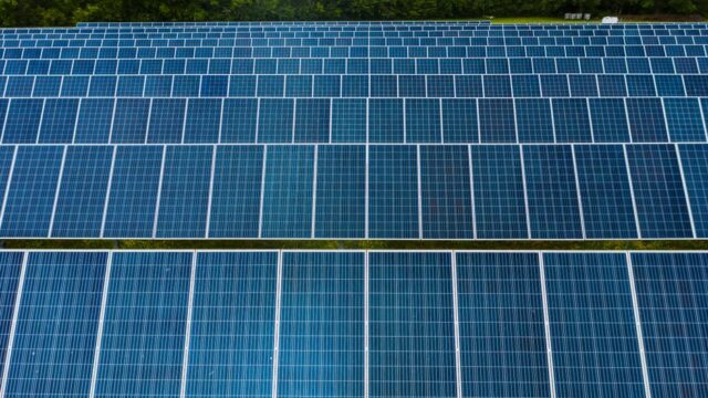 Contemporary installation of solar panels mounted on field in environmental friendly solar power station
