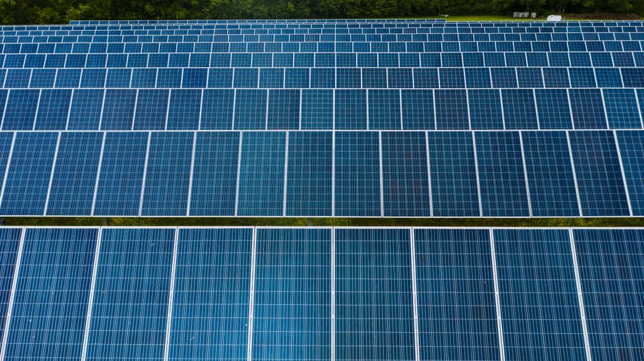 Contemporary installation of solar panels mounted on field in environmental friendly solar power station