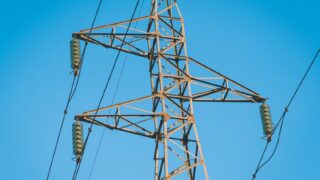 Close-up of a high voltage pylon with a clear blue sky background in Jendouba, Tunisia.