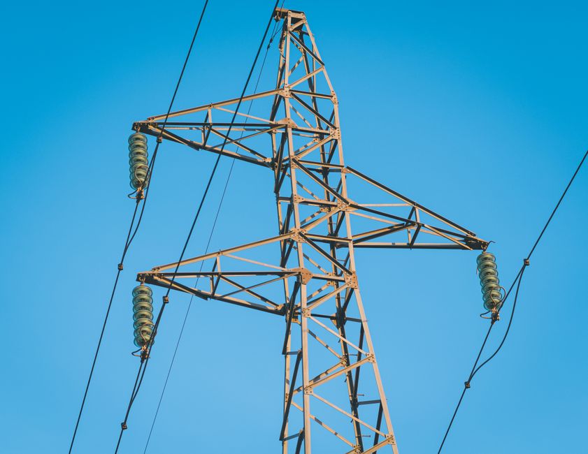 Close-up of a high voltage pylon with a clear blue sky background in Jendouba, Tunisia.