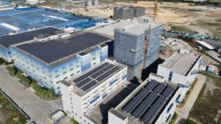 Aerial shot of industrial buildings with solar panels showcases sustainable energy.
