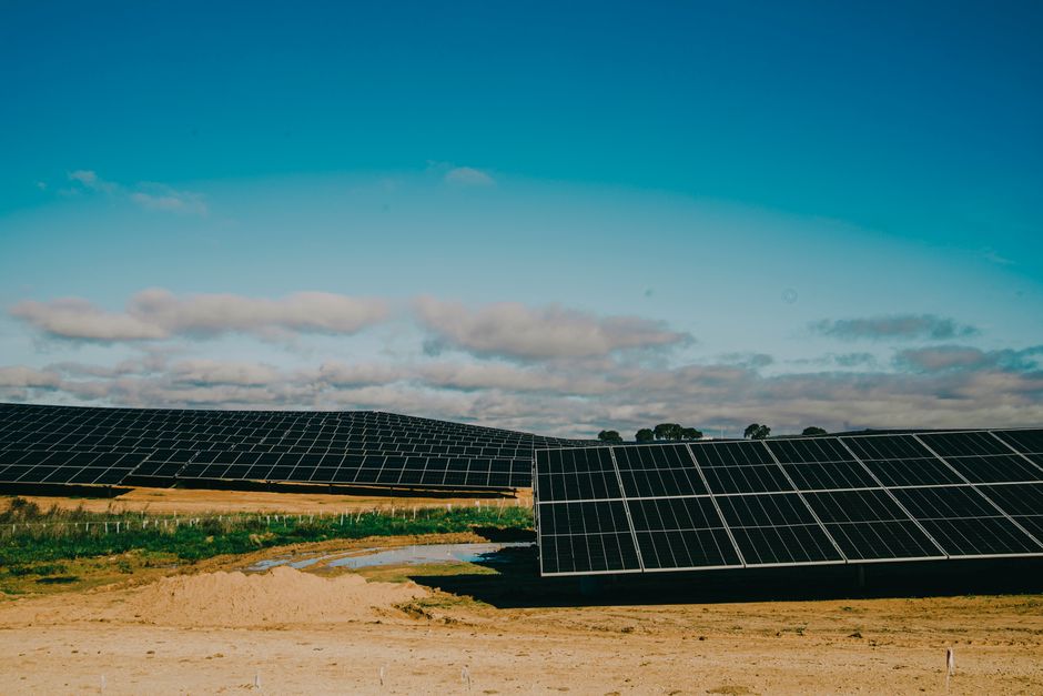 A vast solar farm in a desert setting under clear blue skies, showcasing renewable energy.