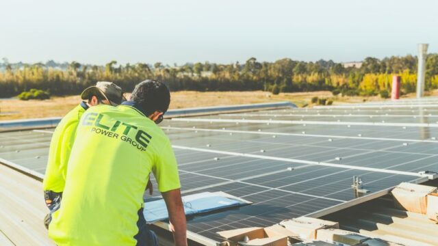 Technicians working on solar panel installation on a rooftop in New South Wales, Australia.