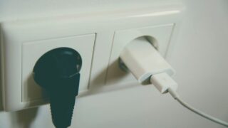 A close-up view of a wall outlet with two plugs inserted, capturing the simplicity of electrical connectivity.