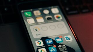 A smartphone with various apps on its screen placed on a keyboard, showing a 31% battery level.