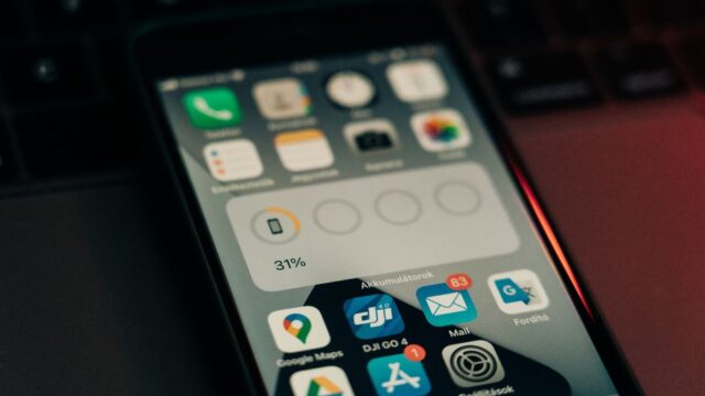 A smartphone with various apps on its screen placed on a keyboard, showing a 31% battery level.