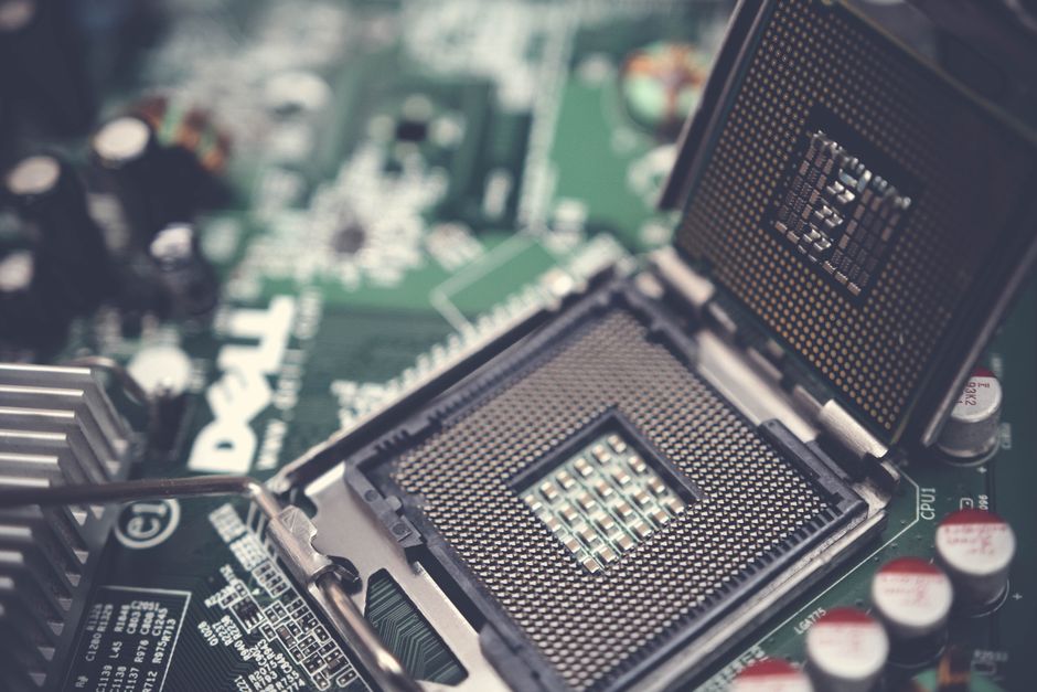 Detailed view of a CPU socket on a green motherboard, showcasing microprocessor technology.