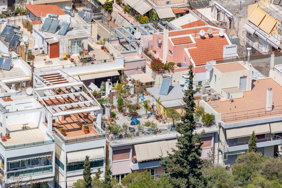 Vibrant urban rooftop gardens with solar panels in a residential district.