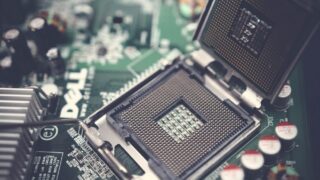 Detailed close-up shot of a computer motherboard featuring an open CPU socket and electronic components.