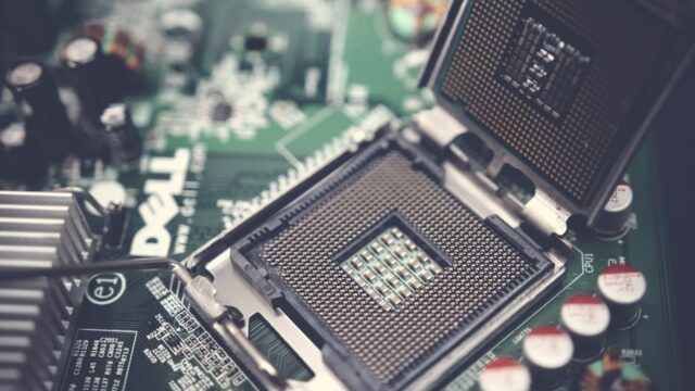 Detailed close-up shot of a computer motherboard featuring an open CPU socket and electronic components.