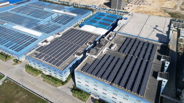 Aerial shot of industrial buildings with solar panels harnessing renewable energy.