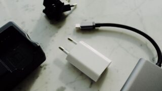 Set of various modern charging unit with adapter and small external battery pack with short cable placed on white marble table