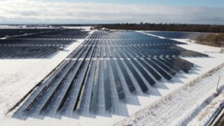 Aerial view of a solar farm in snowy Arnprior, Ontario, showcasing renewable energy.