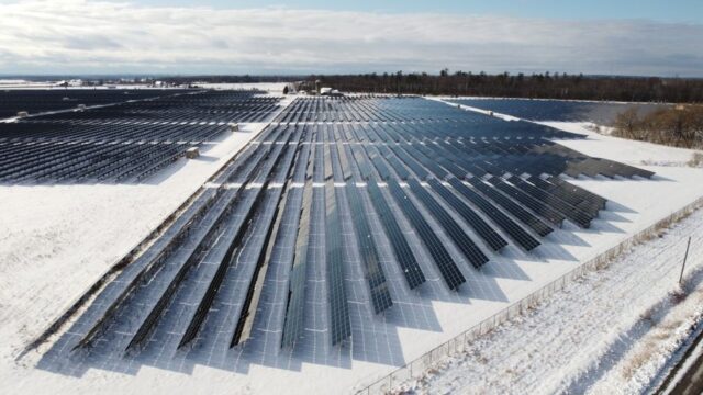 Aerial view of a solar farm in snowy Arnprior, Ontario, showcasing renewable energy.